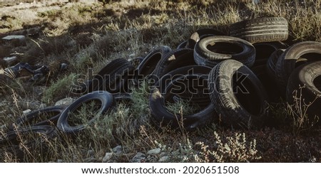 mountain of worn-out tires dumped in the field