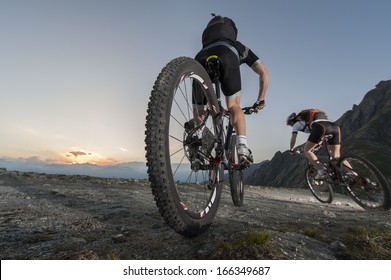 Mountainbike - Two Bikers By Uphill Biking On Sunset - Sunrise