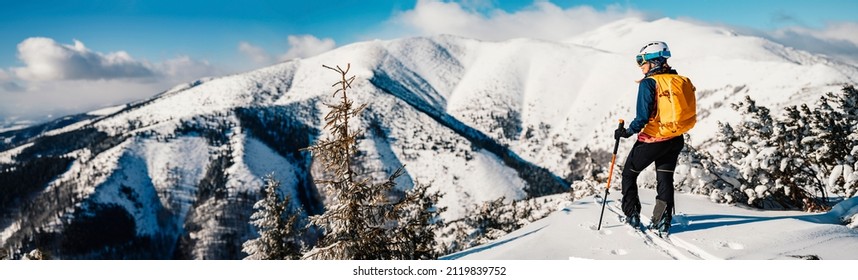 Mountaineer backcountry ski walking ski woman alpinist in the mountains. Ski touring in alpine landscape with snowy trees. Adventure winter sport. Freeride skiing. Banner, panorama