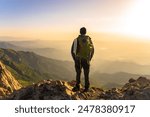 Mountaineer with backpack on top of mountain, travel, mountaineering concept