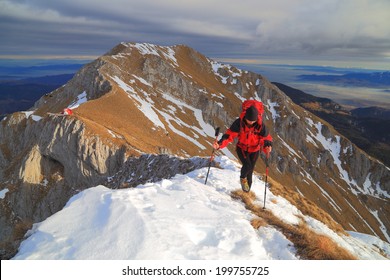 Mountaineer Climbs The Mountain Trail On Snow Patches