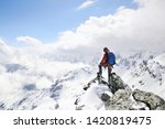 mountaineer on the top of a mountain in the background of the landscape of snowy mountains