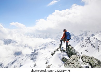Bergsteiger auf der Bergspitze im Hintergrund der Landschaft schneebedeckter Berge