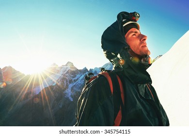 Mountaineer reaches the top of a snowy mountain