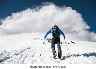 Mountaineer rises uphill to meet a mountain storm coming from the mountain