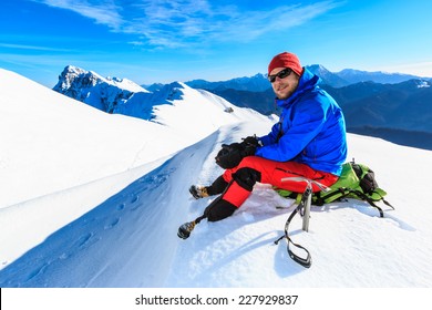 Mountaineer Sitting Resting On The Mountain Top At The Kosuta Ridge In Karavanke Range, Slovenia