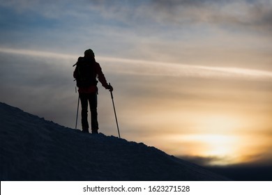 A mountaineer skier watches the sun go down