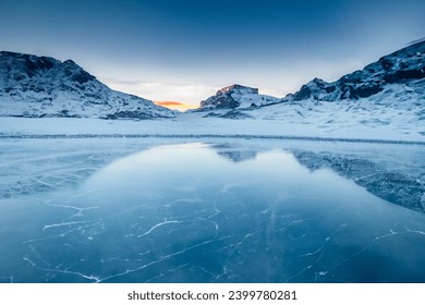  A mountainous, snow-covered landscape with a frozen lake in the foreground. - Powered by Shutterstock