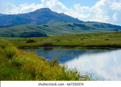 Mountains against the background of the water. Kazakhstan. The Karkaraly Mountains.