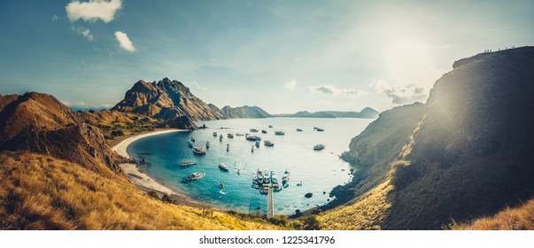 Mountains, bay, sun rays. Aerial shot. Padar. Wonderful panoramic overview the cute bay with the sand beaches surrounded by the mountains. Landscape of Padar island. Komodo National Park. Indonesia.