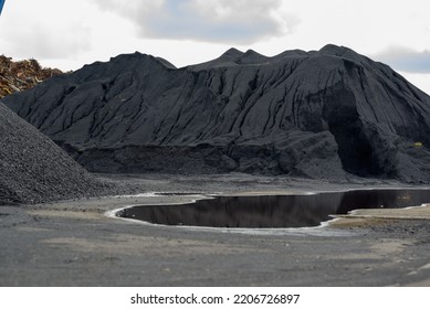 Mountains Of Black Coal In A Concept Of Energy Crisis And Energy Shortage In The Foreground Puddles