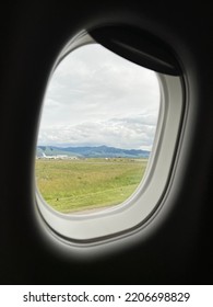 Mountains, Clouds, And A Distant Aircraft Seen Through Passenger Jet Window While Taxiing To Runway At Missoula Montana Airport