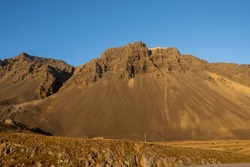 Mountains Covered By Yellow Autumn Vegetation: Grass, Moss And Lichen. Bright Blue Sky With No Cloud. East Iceland.