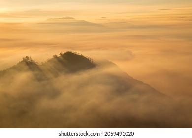 Mountains in Indonesia showing smoke, haze and air pollution  through tree lined mountain ridges at sunrise