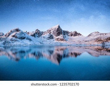 Mountains At The Night Time. Mountains And Reflections On The Water Surface On Lofoten Islands, Norway. Starry Sky Over The Mountains. Winter Landscape On Lofoten Islands, Norway. 