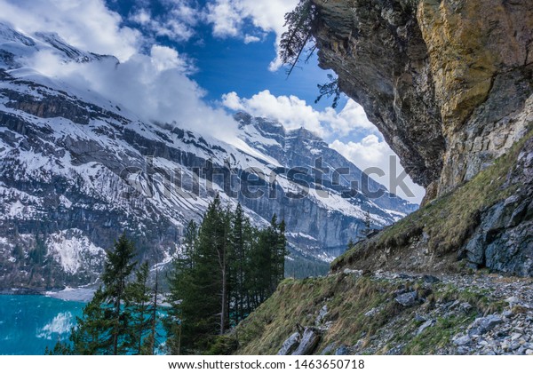 The mountains reflected in\
the bright blue still waters of the lake at oeschinensee in\
switzerland