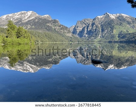 mountains reflected in a lake with a rock in the foreground