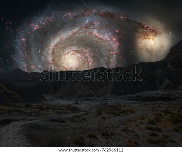 Mountains ridges on the background of outer space\
galaxy, photomontage made from a photograph of the M51 galaxy taken\
by the Hubble Space Telescope of NASA and another of the desert\
tabernas in Spain.