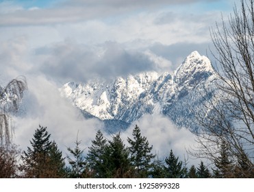 mountains with snow looking through clouds