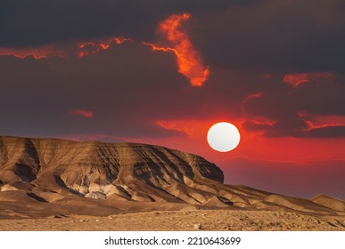 The mountains of Sodom located on the south-west side of the Dead Sea. Sunset on a foggy mountain range Sodom. Evening red sunset sky over mountain Sodom Gomorrah in Dead sea from Negev desert, Israel