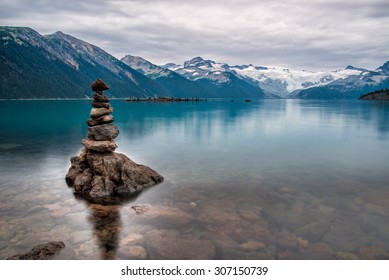Mountains surrounding Turquoise lake with rock pile