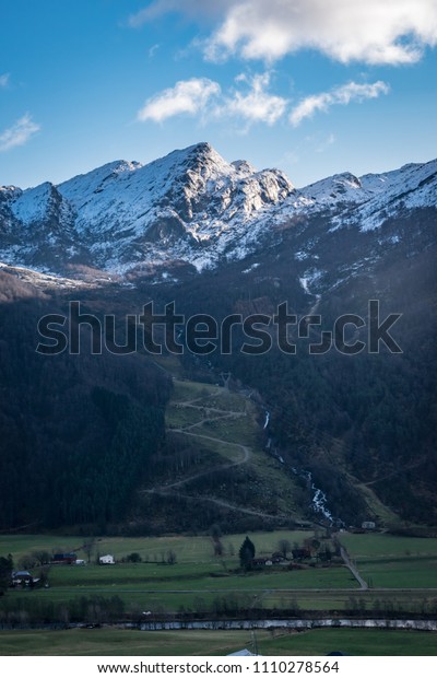 Mountains valley\
snow line winding road\
Norway