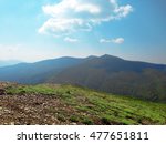 Mountains view. Mountains with blue sky, Ukraine, Dragobat city. Mountains valley with blue sky and rocky road with fresh green grass on the foreground