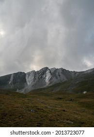 Mountains Of White And Silver Stone With Grass Field In The Foreground. In The Pyrenees. Vall De Coma De Vaca And Mountains Of Vallter.