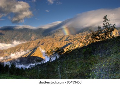 A  Mountaintop On A Windy Day In Costa Rica, Forming This Rainbow Through The Pacific Side Of The Mountain Slope