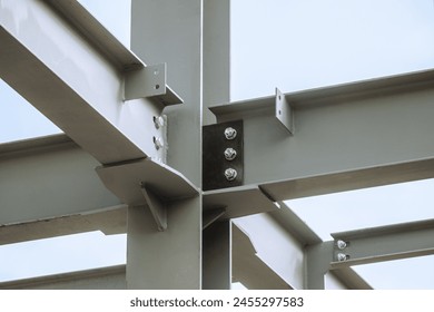 Mounting bolted connection of steel beams before welding. Metal construction covered protective gray primer. Close-up. - Powered by Shutterstock