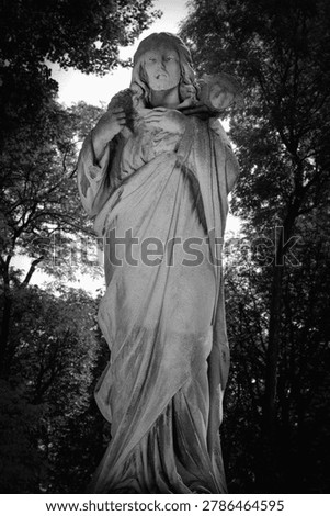 Mourning angel statue in dramatic black and white composition.