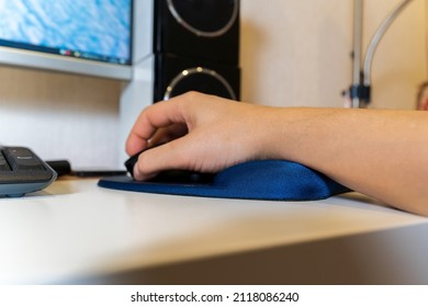 Mouse pads with a gel pad under the wrist. A man hand is working at the computer. Selective focus