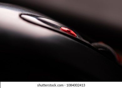 The mouse with a wheel and red button on a black background. Close-up macro view in noir style.