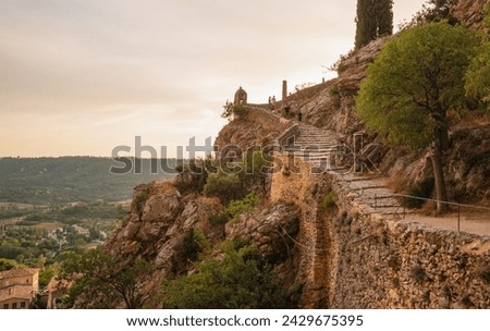 Moustiers-Sainte-Marie panoramic view of stone staircase on the hillside way to the Chapelle Notre-Dame de Beauvoir overlooking the medieval village,  France.