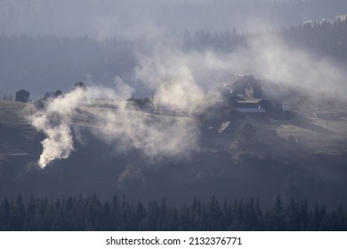 Moutain landscape. Lot of smoke coming out of a chimney from an old house in Lupcina, Romania - Powered by Shutterstock