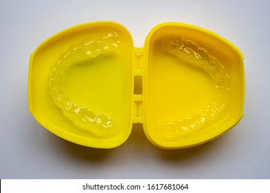 Mouth Guard On A Yellow Case With A White Background