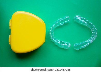 Mouth Guard With A Yellow Case On The Right With Green Background