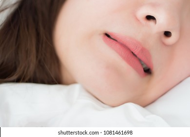 mouth of woman with grinding teeth, bruxism symptoms; mouth close up portrait of sleeping woman grinding her teeth with stress; mouth, oral, dental care medical concept; asian adult woman model