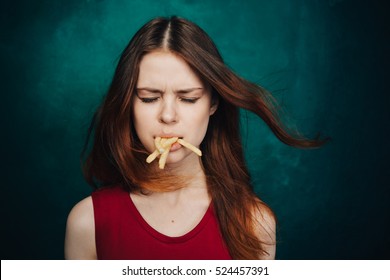 
Mouthful Potato Fries. A Woman With Her Mouth Full. Failure To Diet