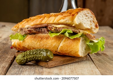 A Mouth-watering Big Cuban Sandwich With Baked Pork, Cheese And Pickled Cucumbers In A Toasted Baguette.