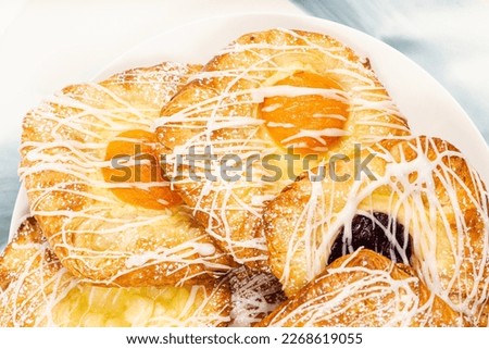 Mouth-watering blueberry, apricot, and apple fruit danish topped with fondant and icing sugar.