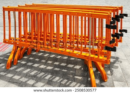 Movable foldable temporary orange plastic barrier sections for regulating people flow at events