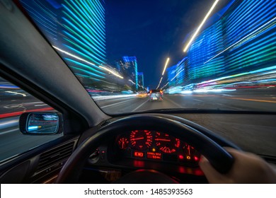 Movement of the car at night at high speed view from the interior with driver hands on wheel. Concept spped of life.