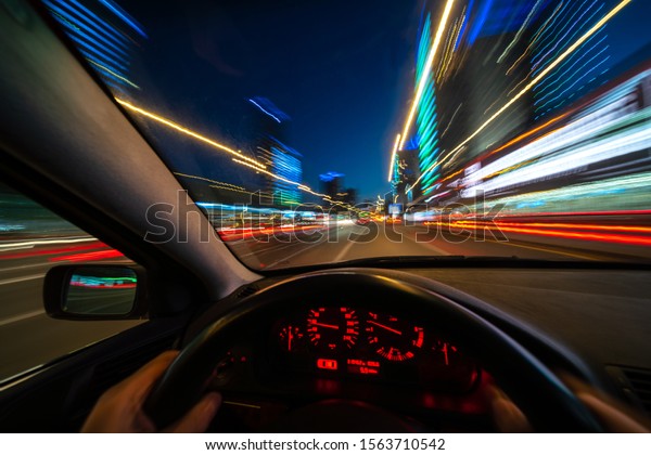Movement of\
the car at night at high speed view from the interior with driver\
hands on wheel. Concept speed of\
life.