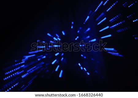 Movement of light. Concept of speed. Blue stars or dots. Dark background.