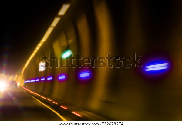 Movement on the car on a dark tunnel with\
artificial lighting.