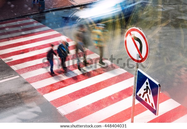 movement of people and cars on the\
pedestrian crossing the intersection, blurred\
motion