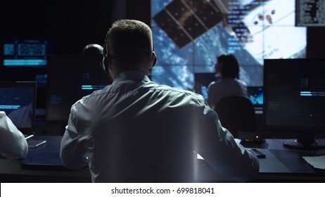 Movement Shot Back View Of Man Working On Space Mission In Control Center. Elements Of This Image Furnished By NASA.