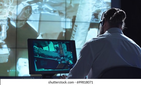 Movement Shot Back View Of Man Working On Space Mission In Control Center. Elements Of This Image Furnished By NASA.