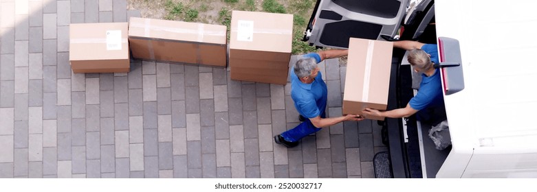 Movers carrying heavy boxes while moving with truck